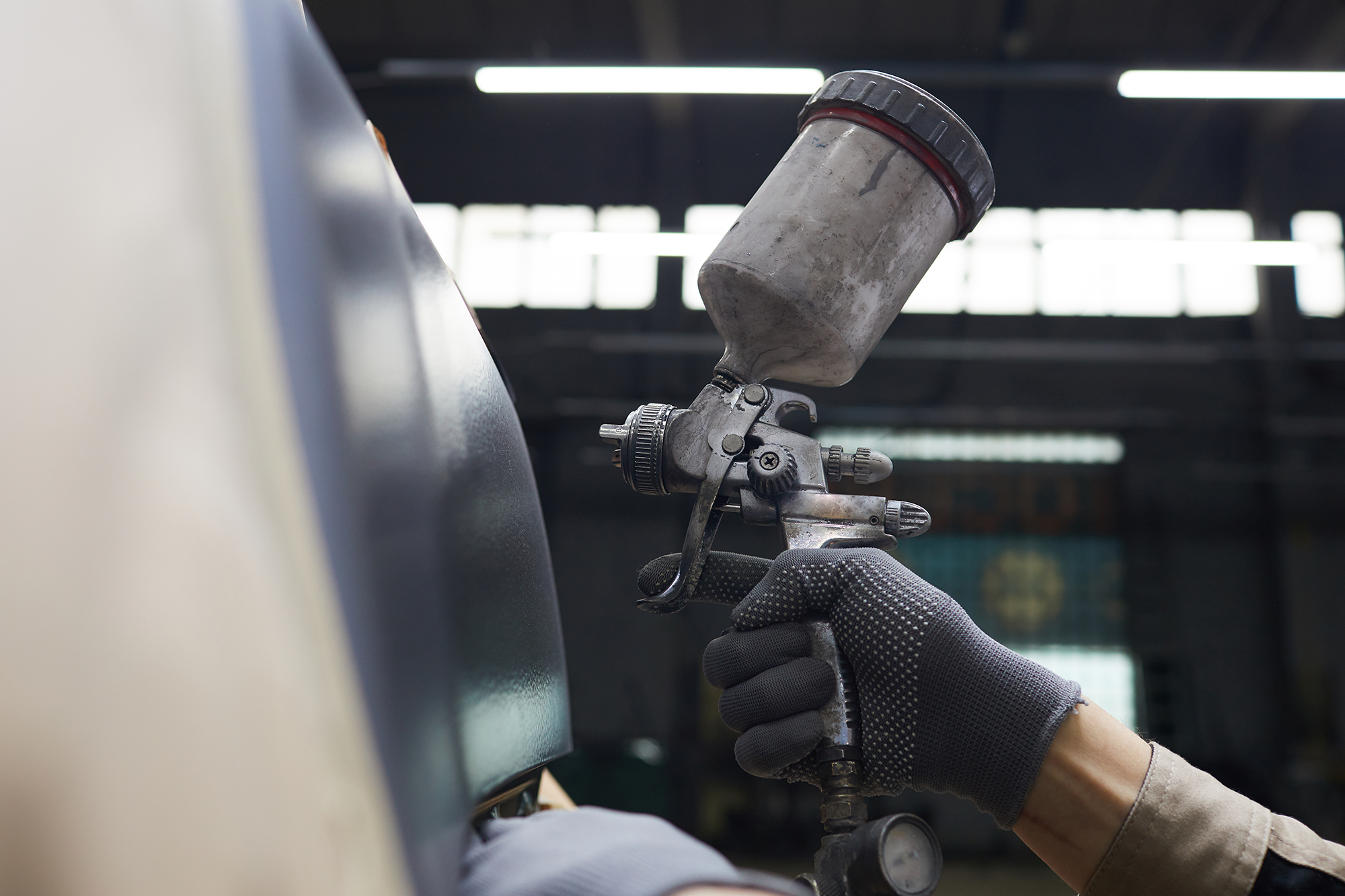 hand-with-spray-gun-painting-car-Y2J9TRP